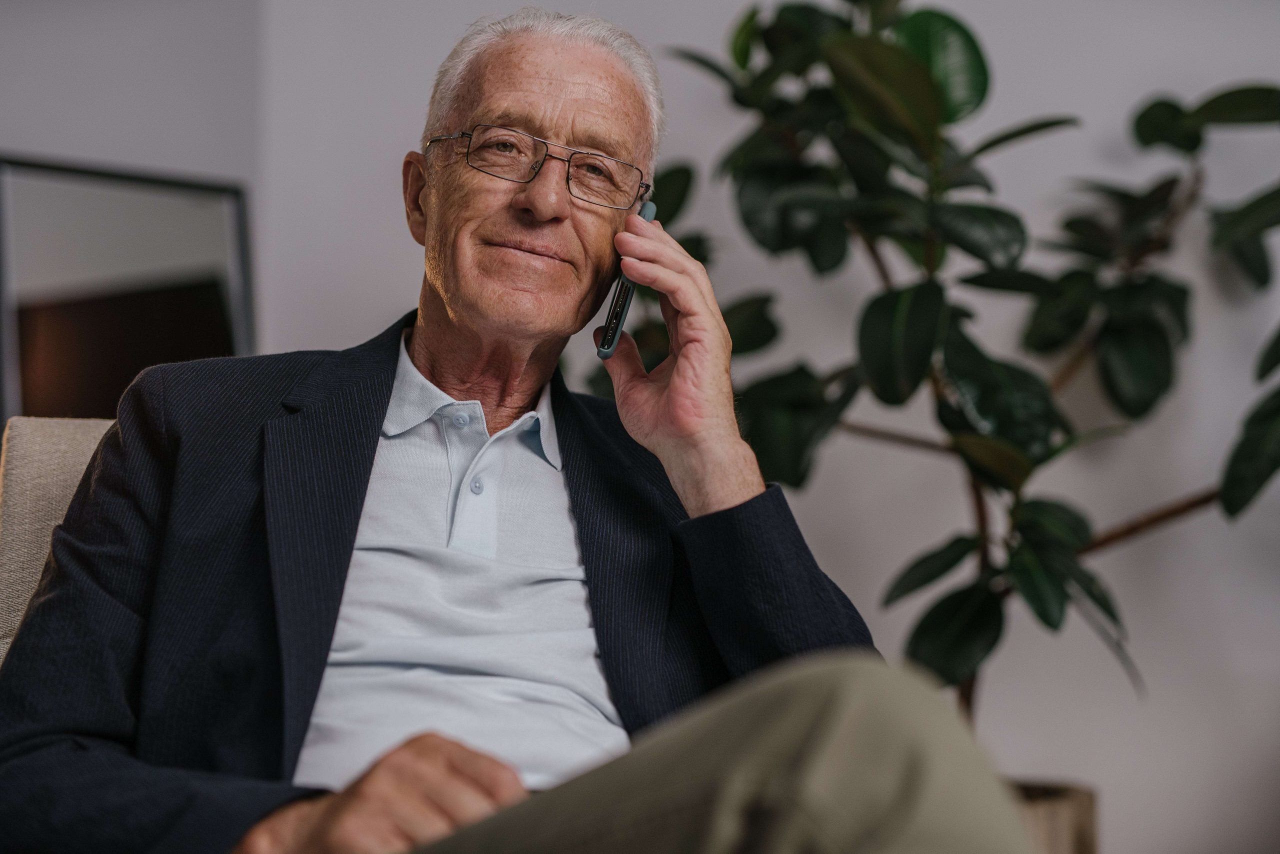 Elderly man discussing pension release options on the phone