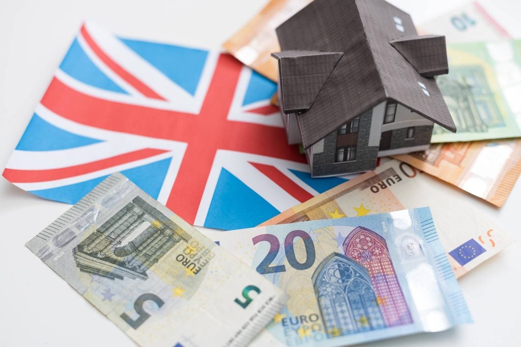 UK flag and house model illustrating can foreigners buy property in UK