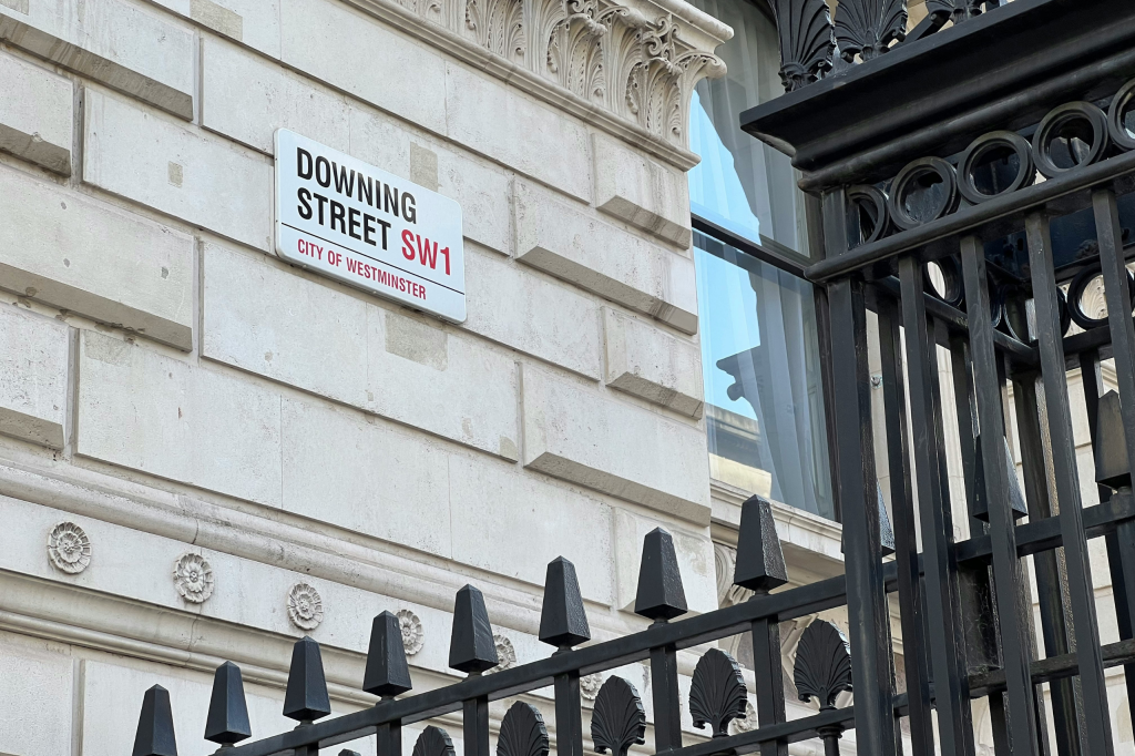 Downing Street SW1 street sign on a historic government building in Westminster, London.