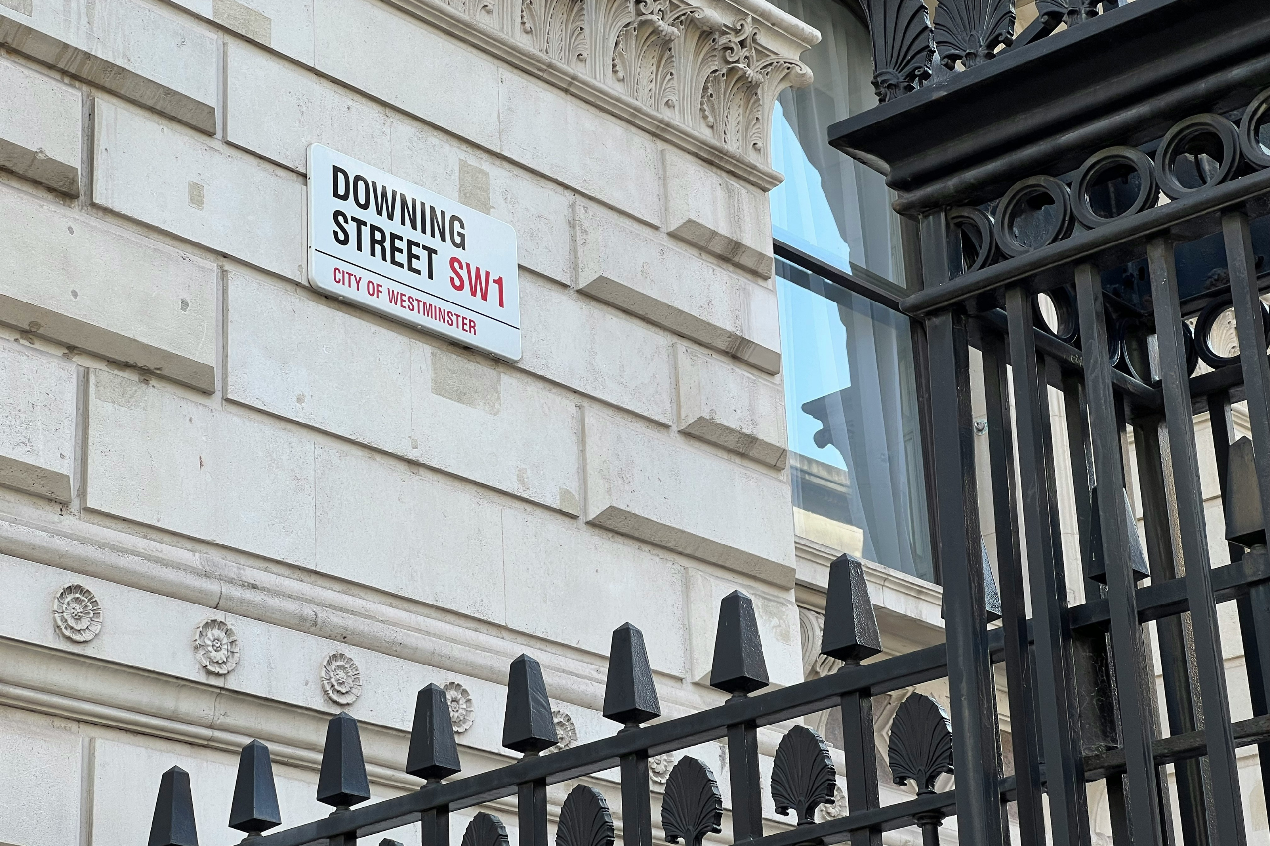 Downing Street SW1 street sign on a historic government building in Westminster, London.
